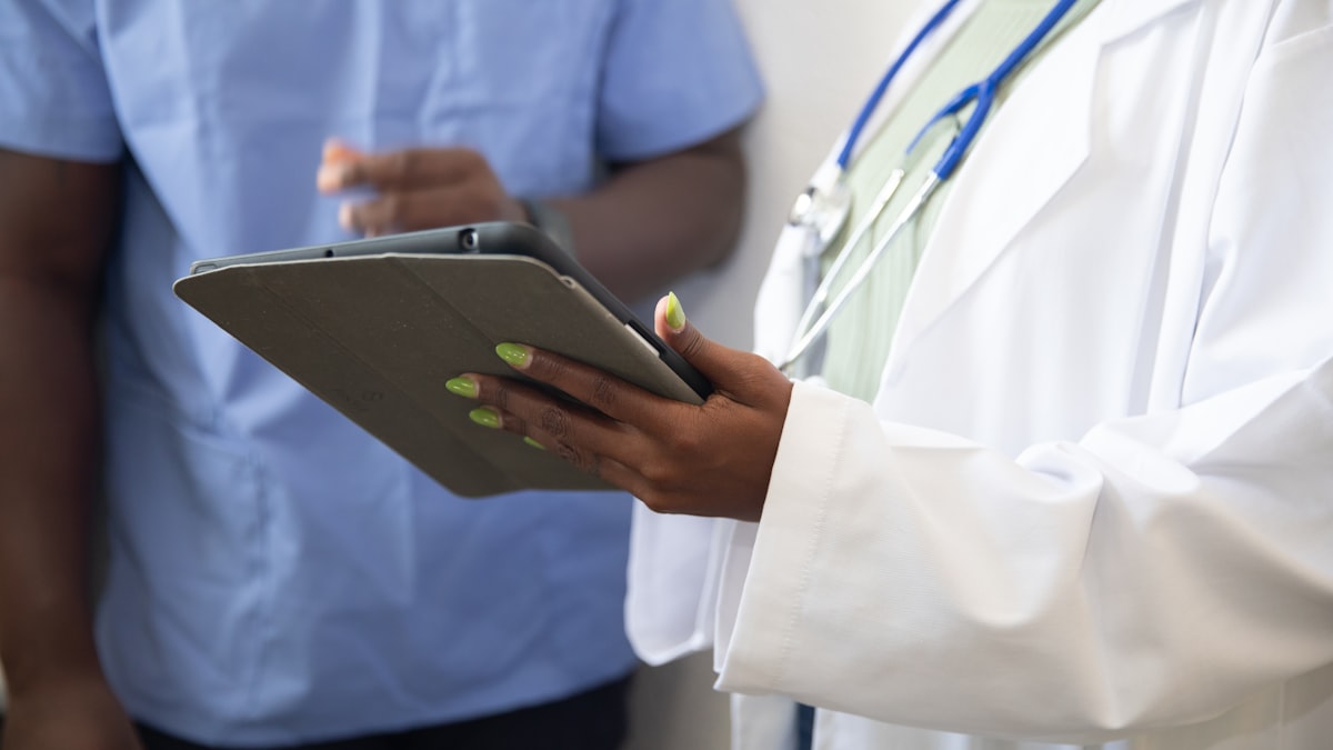Doctor showing patient information on tablet — building a HIPAA-compliant file transfer workflow for healthcare providers