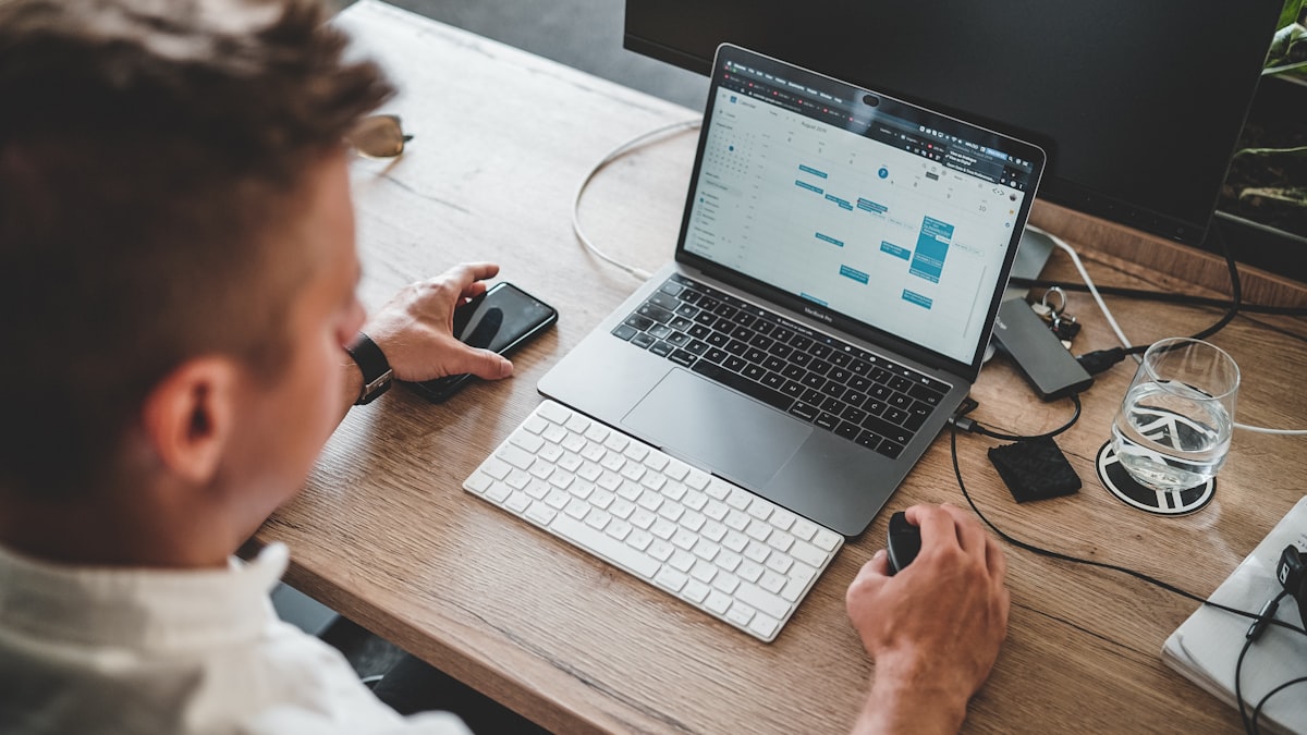 Professional working on laptop with iPhone in office — what to do when your IT policy doesn't cover external file transfers