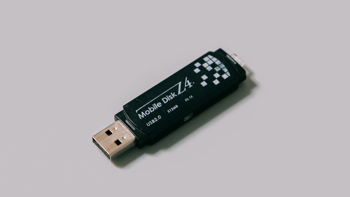 USB flash drive on white surface — the risk of permanent cloud links that outlast every large file transfer